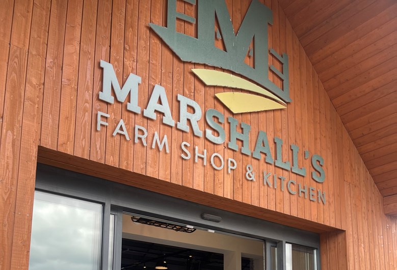 Exterior entrance of a shop showing the shop name. Text on image: Marshall's Farm Shop & Kitchen.