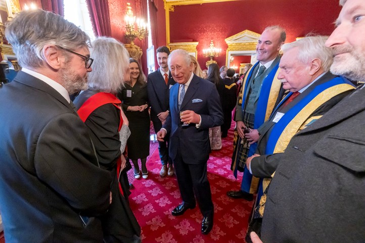 A group of people standing around King Charles