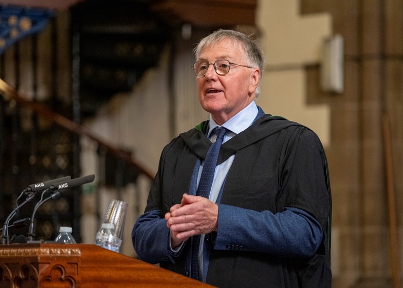 Man speaking into a microphone at a graduation