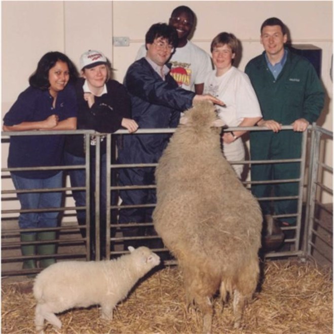Young Eileen wearing a baseball cap with Dolly the sheep