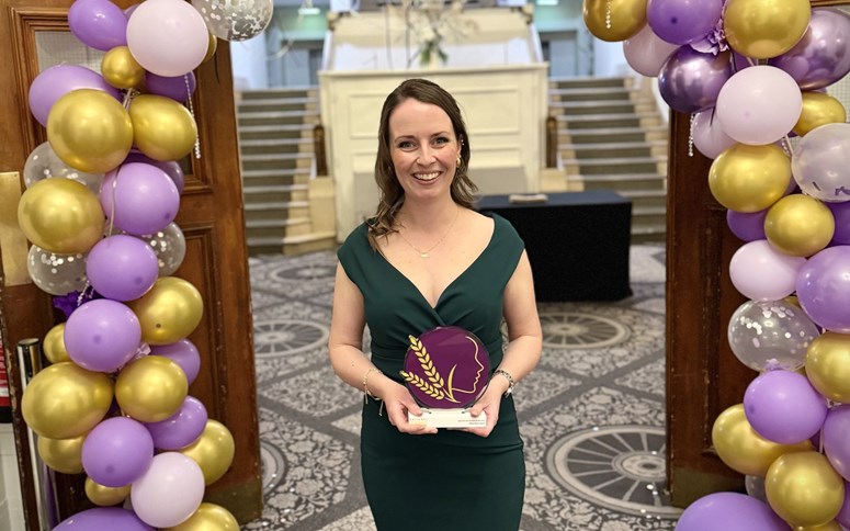 Woman smiling with a trophy.